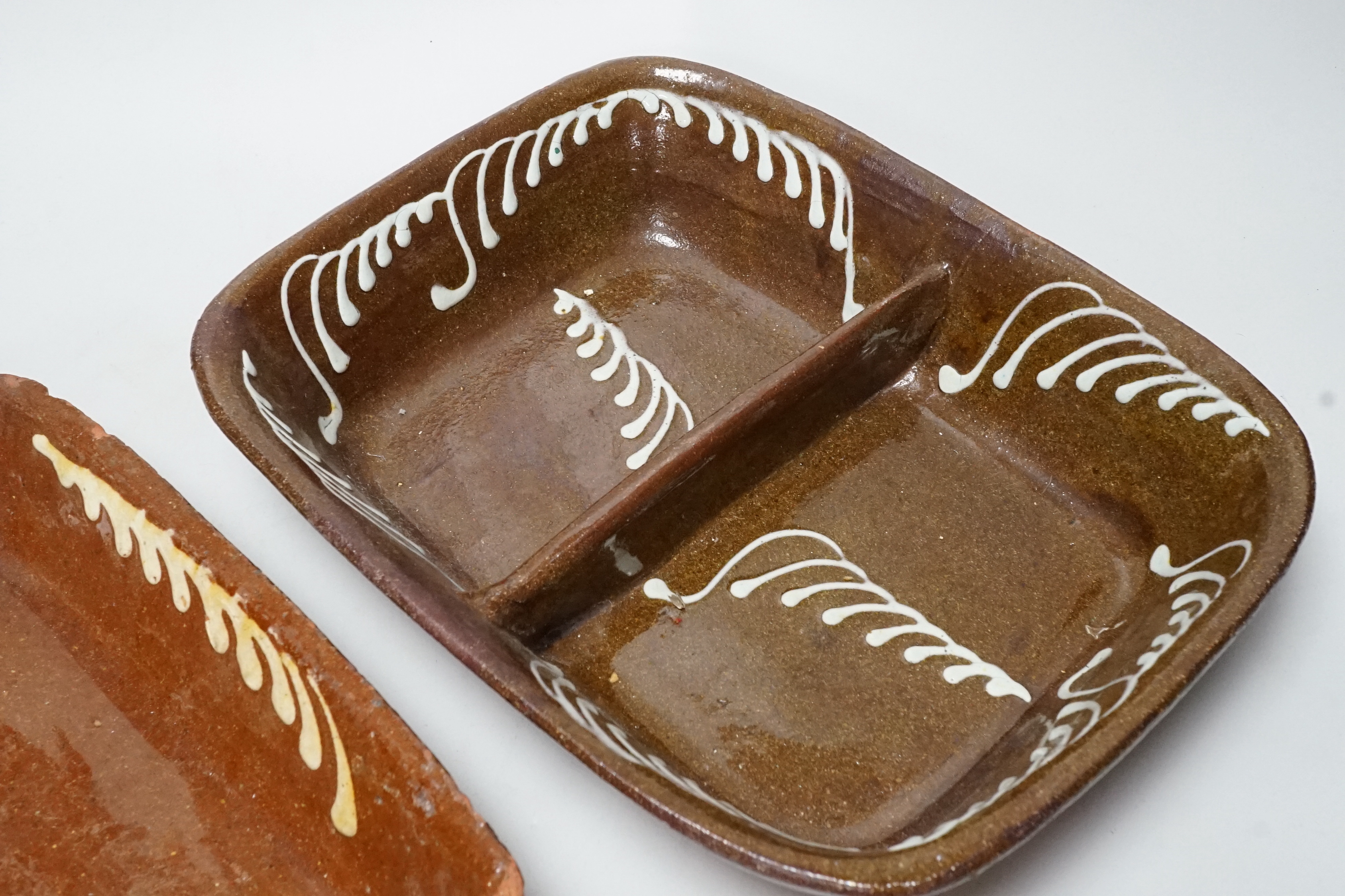 A 19th century slipware baking dish, 27cm wide, together with a twin division dish, 30cm